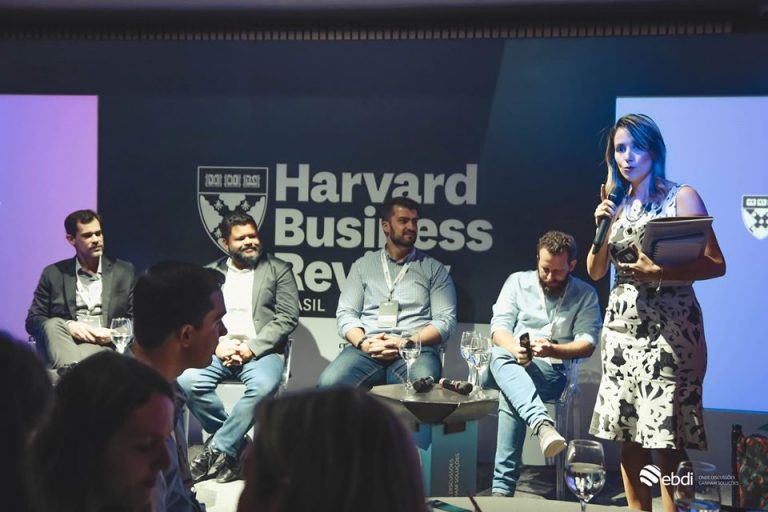 Encontro corporativo sobre data analytics em parceria com a HBR BR, no palco esta acontecendo um painel de debates com três executivos
